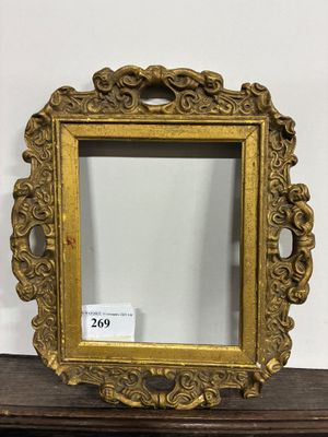 un miroir à cadre doré posé sur une table en bois