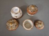 four pieces of porcelain are arranged in a circle on a table