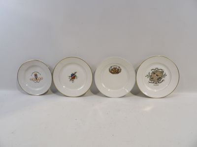 four plates with different designs are lined up on a white surface