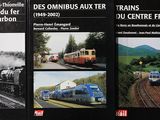 trois livres posés sur une table, avec des images de trains sur la couverture