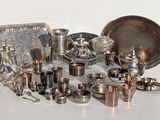 many different types of silverware on a white table