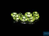 a close up of a group of green gems on a black surface