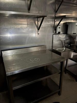 une grande cuisine en inox équipée d'une cuisinière et d'un évier