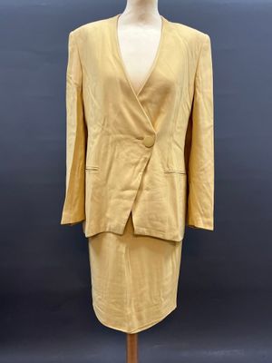 une photo d'une robe et d'une veste posées sur un mannequin de vitrine