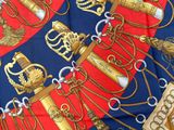 a red and blue scarf with gold and silver items on it