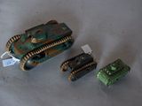 three toy tanks sitting next to each other on a table