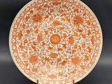 une assiette orange et blanche ornée d'un motif floral