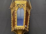 a gold lantern hanging on the wall with a blue sky in the background