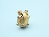 an image of a small gold pig charm with colorful stones on it