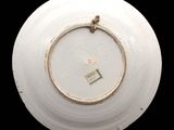 a white plate with a gold rim on a black background
