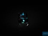 un gros plan d'une bague dans l'obscurité, ornée d'une pierre verte qui brille
