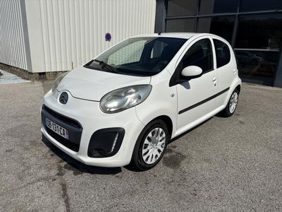 la petite voiture blanche est garée devant un bâtiment
