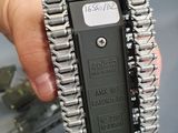 a person holding a metal chain that is attached to a cell phone