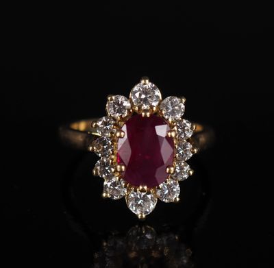 une bague en or sertie d'un rubis entouré de diamants blancs