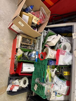 une valise remplie d'objets posée par terre