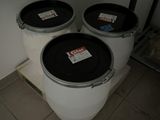 three white barrels sitting next to each other on a tiled floor