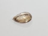 a close up of a tear shaped diamond on a white surface