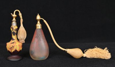 deux vases et un pinceau posés sur une surface noire