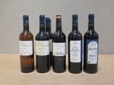 six bouteilles de vin sont alignées sur une table