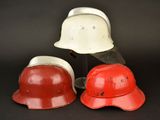 two red and white helmets sitting next to each other on a black surface