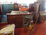 a room filled with antique furniture and a baby stroller