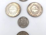 a group of five different coins sitting on top of a white surface