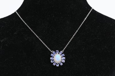 un collier composé d'une pierre d'oplite blanche entourée de cristaux violets, présenté sur un mannequin noir