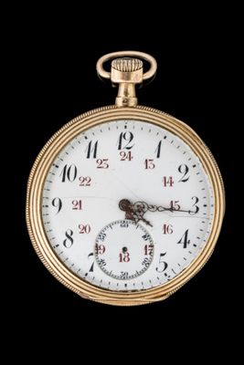 gros plan d'une montre de poche en or sur fond noir
