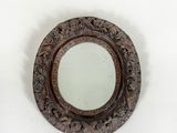 une image représentant un miroir rond accroché au mur, sur fond blanc
