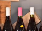 several bottles of wine are lined up in a row on a shelf