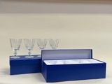 quatre verres à vin dans une boîte bleue posée sur une table