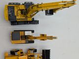two toy construction vehicles on a white surface