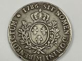 a close up of a silver coin with a crown on it