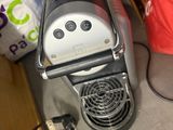 a coffee maker sitting on the floor next to other items