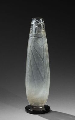 un vase en verre orné d'un motif, posé sur un socle noir