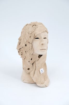 a clay sculpture of a woman ' s head wearing a hat