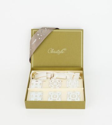 a green box with four candles and a ribbon in it