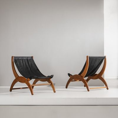deux fauteuils en cuir noir posés sur une estrade blanche dans une pièce blanche