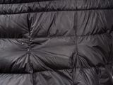 the back of a black down jacket with a hood and zippers