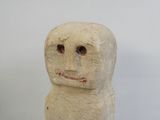 une statue en pierre représentant un homme au visage souriant