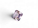 un gros plan d'une pierre violette posée sur une surface blanche