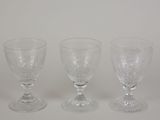 three clear glass goblets sitting next to each other on a white surface