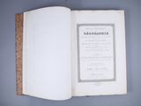 an open book on a blue surface with a black and white border
