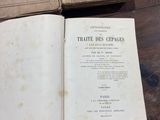 two old books sitting on top of a wooden table next to each other