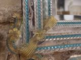 a mirror hanging on a stone wall with a rope around it