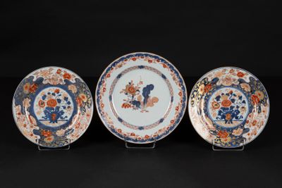 three plates with flowers and birds on them on a black surface
