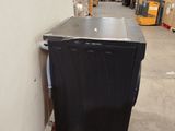 an image of a black refrigerator in a warehouse