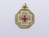 a gold pendant with a pink cross on it