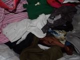 a pile of clothes on a bed in a room