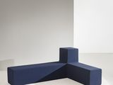 un grand meuble bleu posé sur une table blanche